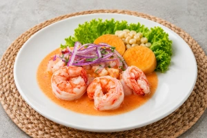 Langostinos frescos sobre lecho de cebolla morada y limón en plato blanco
